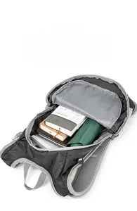 Internal view of black outdoor backpack storing an A5 notebook and green folding umbrella
