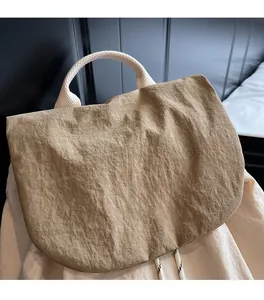 Detail showing the pleated khaki nylon fabric and brand logo on the large casual tote bag