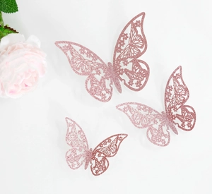 Macro detallada de tres pegatinas de mariposa 3D rosa con purpurina y patrones florales huecos
