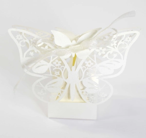 Close-up of laser-cut butterfly wedding favor box with intricate floral patterns and ribbon