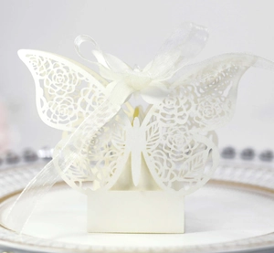 Intricate laser-cut butterfly gift box with floral patterns on a gold-rimmed ceramic plate