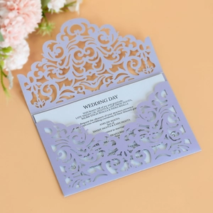 Detail of laser-cut lavender wedding invitation with elegant floral hollow pattern