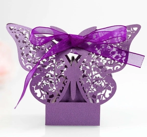 Detail of laser-cut butterfly gift box in purple with silk ribbon for wedding candy
