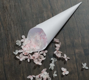Detail of pink hydrangea petals in a white paper cone for wedding decor and DIY events