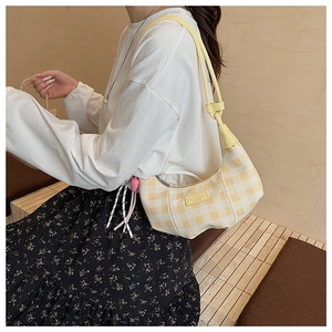 Detail of checkered crescent bag with knot strap and branded leather label
