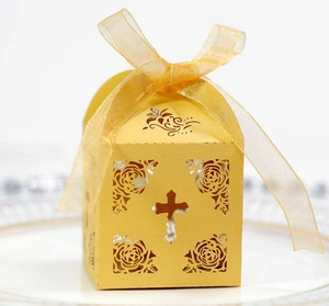Golden laser-cut cross gift box with rose patterns and ribbon for wedding favors