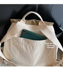 Detail showing back pocket of cream white nylon backpack for convenient tablet storage