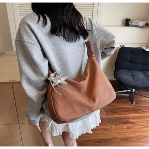 Detailed texture of caramel hobo bag with wave-knit pattern and silver star charm