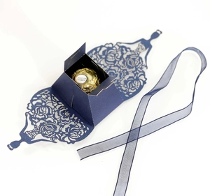 Detailed laser-cut dark blue hollow favor box with elegant floral patterns and ribbon