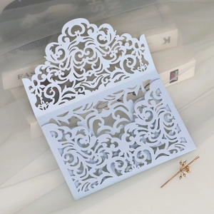 Close-up of light blue laser-cut baroque lace wedding invitation sleeve with pearl finish