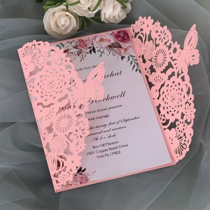 Dettaglio dell'invito di nozze rosa tagliato al laser con motivi floreali e farfalle