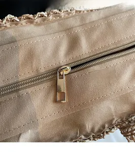 Detailed close-up of smooth gold metal zipper on woven canvas tote handbag