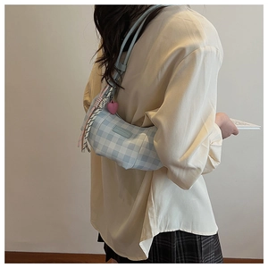 Detail of blue gingham crescent bag with pink heart pendant and decorative silk scarf