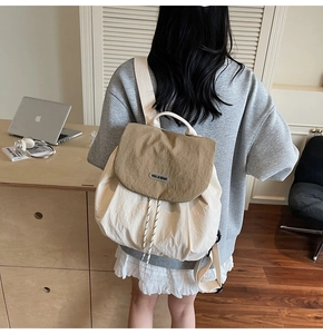 Detail of a beige patchwork backpack with nylon texture and woven shoulder straps