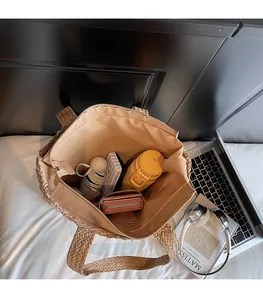 Detailed top view of large capacity woven tote bag interior with beige fabric lining
