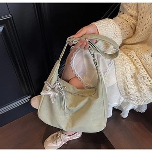 Detail of sage green canvas tote with herringbone texture and silver star charm