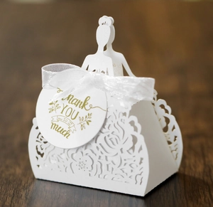 Detailed laser-cut white wedding favor box with floral patterns and bride groom silhouette