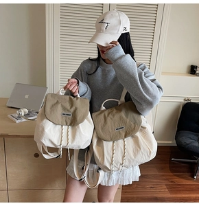 Detailed view of cream and khaki nylon backpack with drawstring and flap closure