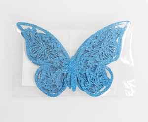 Detalle de mariposa decorativa azul con purpurina y diseño calado con efecto 3D
