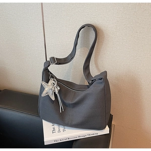 Detail of dark grey canvas tote featuring V-pattern texture and silver star zipper charm