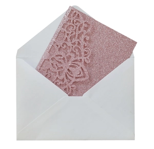 Detailed laser-cut pink glitter wedding invitation with floral patterns and envelope