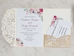 Detail of laser cut rose pattern wedding invitation with floral card and gold glitter sleeve