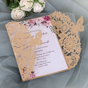 Vista macro dell'invito di nozze laserato con farfalla glitterata e motivi floreali