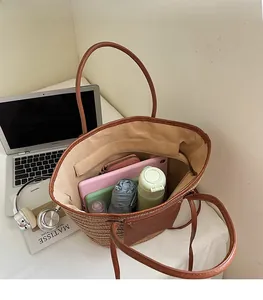 Interior view showing large capacity of the woven straw tote bag with office essentials