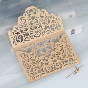 Detailed laser cut lace pattern on champagne gold pearlescent paper invitation cover
