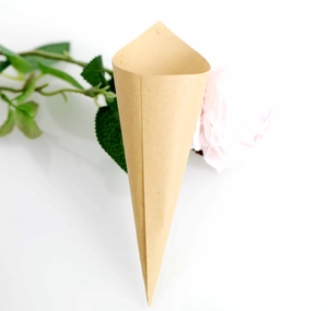 Close-up of a rustic kraft paper confetti cone with pink floral decor for weddings