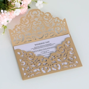 Detail of gold laser-cut wedding invitation with elegant floral hollow patterns