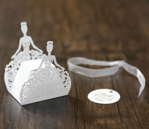 Detail of laser-cut white wedding favor box with bride silhouette and floral hollow pattern