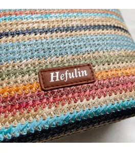 Détail du tissage en paille colorée et du patch logo en cuir sur un sac seau élégant