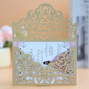 Macro detail of laser-cut gold wedding invitation with intricate floral lace pattern