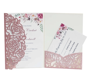 Detail of rose gold glitter laser-cut wedding invitation with hollow floral patterns