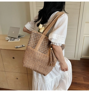 Detail of woven straw tote bag with lace trim and tassel, styled on a white dress