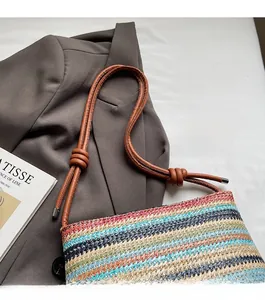 Détail du sac seau tissé avec rayures multicolores et bandoulière en cuir marron