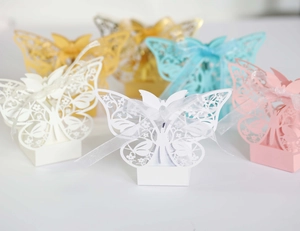 Detailed laser-cut butterfly wedding candy boxes with ribbons in various pastel colors
