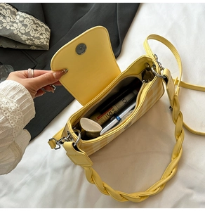 Detail of yellow checkered bag interior showing cosmetics and magnetic silver clasp