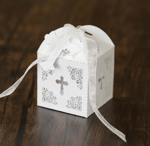 Detail showing white laser-cut paper gift box with cross and rose hollow pattern