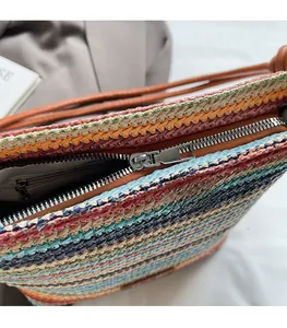Détail macro du zip en métal argenté et texture de paille tissée colorée sur sac seau