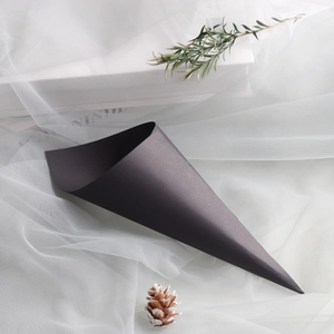 Detail of elegant black matte cone packaging for wedding petals on white tulle background