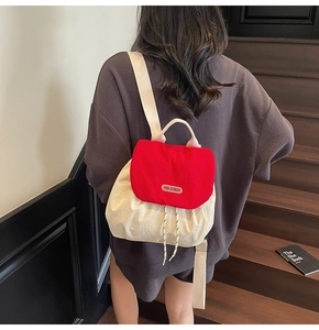 Detail of red and white contrast mini backpack with drawstring and brand logo