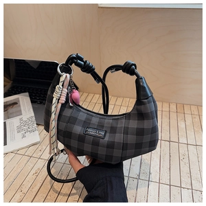 Detail of grey plaid crescent bag with knot leather handle and heart-shaped charm