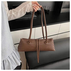 Detail of the brown leather woven shoulder bag with fine texture and zipper tassel fringe