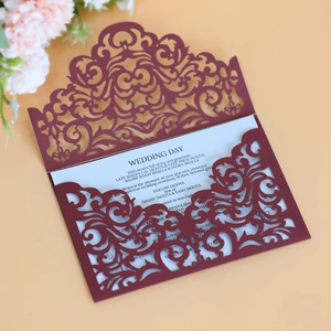 Detailed laser cut burgundy wedding invitation card with intricate scrollwork patterns
