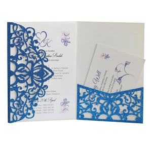 Detail of laser cut blue glitter wedding invitation with intricate mandala lace pattern