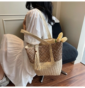 Detail of hand-woven straw tote bag featuring intricate floral crochet and wood bead tassel