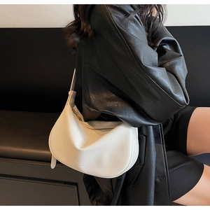 Detail of white crescent leather bag with pebble texture and debossed KK logo branding