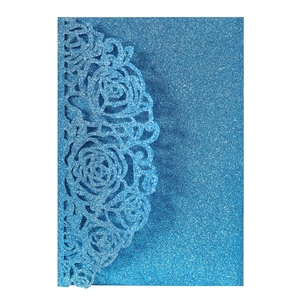 Detail of blue glitter laser-cut invitation card with hollowed rose floral pattern